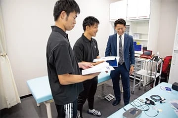 JFA 夢フィールド(海浜幕張)内のトレーナールームに設置された低周波治療器、超音波治療器、超短波治療器等と製品説明の様子